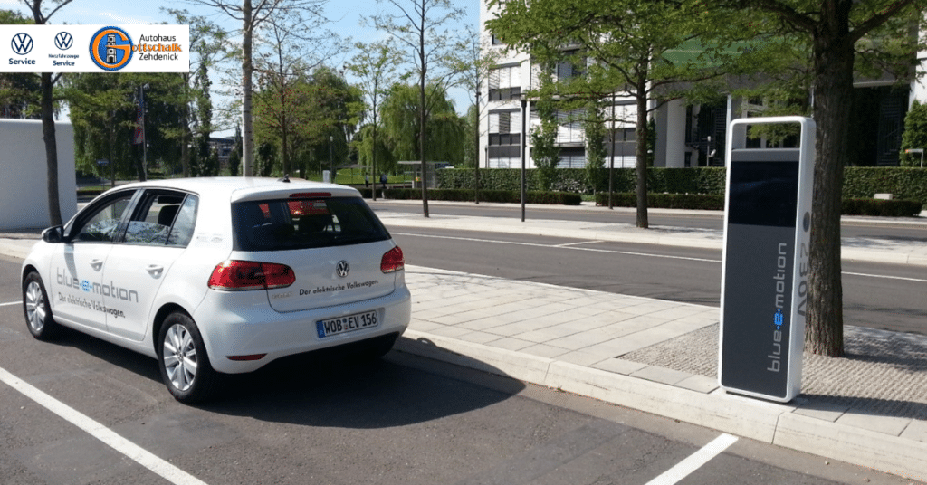 VW-Golf als E-Auto steht auf dem Parkplatz an einer Ladesäule